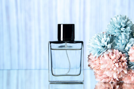 front-view-elegant-perfume-bottle-colored-flowers-light-blue-background-1-434x290