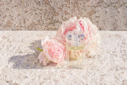 transparent-bottle-perfume-against-background-stone-slab-pink-fragrant-peony-perfumes-natural-cosmetics-with-notes-colors